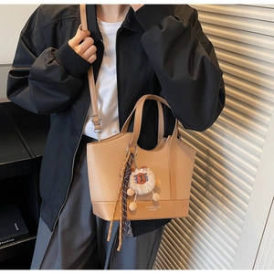 Khaki Eimer-Handtasche mit Litschi-Muster, Plüsch-Löwenanhänger und modischem Griff