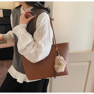 Detailopname van bruine kunstlederen shopper met een schattige pluche beer aan model