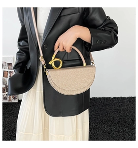 Detailed macro of the champagne gold glitter texture and round metal buckle on the handbag