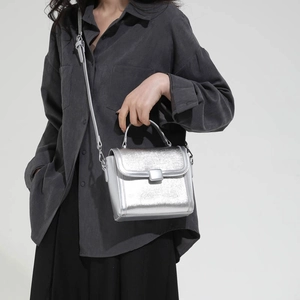 Chic silver metallic textured handbag with top handle and adjustable shoulder strap