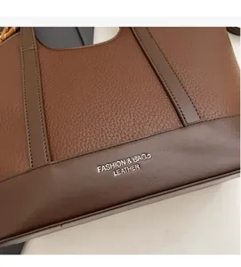 Nahaufnahme der Lederstruktur mit Lychee-Muster und Prägung auf der braunen Tasche