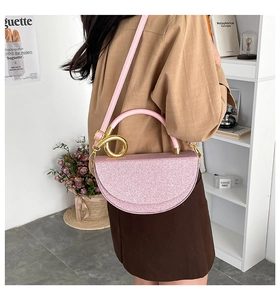 Detail of pink sequin saddle bag with golden metal ring handle for stylish women