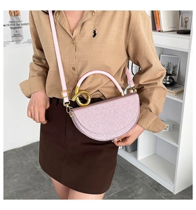 Detailed side view of a pink glitter saddle bag with a decorative gold metal ring