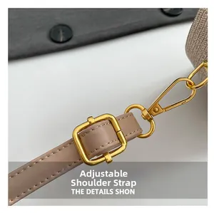 Detail of adjustable khaki leather shoulder strap with polished gold-tone metal hardware
