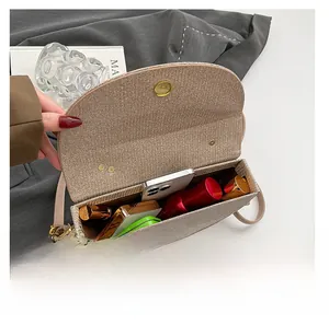 Detail view of woven crossbody bag interior showing storage for phone and cosmetics