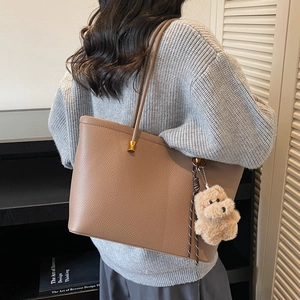 Bruine leren shopper met goudkleurige hardware en een zachte puppy-hanger aan de schouder