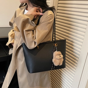 Klassieke zwarte lederen tote bag met teddybeer-bedeltje en gouden hardware accenten