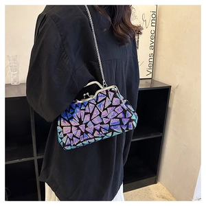 Detail of glitter sequin patchwork clutch with silver chain strap on a black shirt