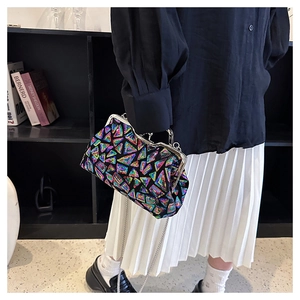 Detail of colorful geometric sequin clutch with silver chain strap on a model