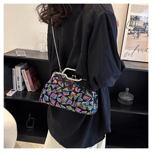 Detail shot of a colorful sequined clutch bag worn as a crossbody with a silver chain strap
