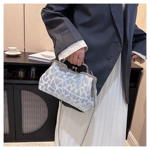 Chic silver sequined evening shell bag with metal chain shown in lifestyle setting