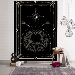 Detail view of a black and gold tarot tapestry hanging on a white brick wall in a cozy room