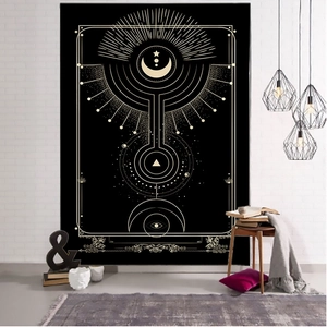 Detail of a black tarot tapestry with golden mystical moon and star symbols on brick wall