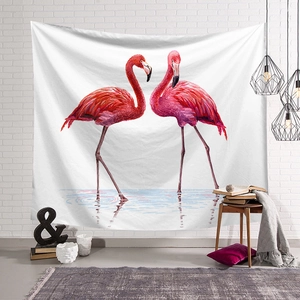 Detail of pink flamingo wall tapestry hanging on a white brick wall in a cozy bedroom decor