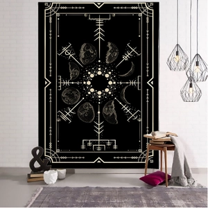 Detail of tarot tapestry showing lunar phases and Nordic runes on a white brick wall