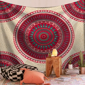 Detail of bohemian mandala tapestry hanging on a wall with cozy home decor and pillows