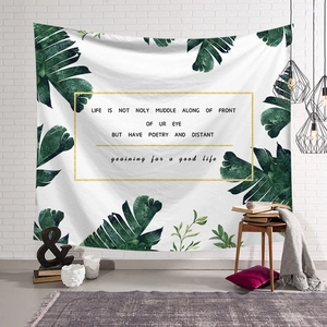 Nordic minimalist tapestry with tropical leaf design and motivational text on white brick wall