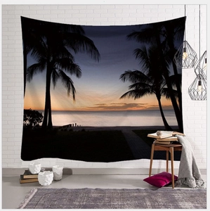 Detailed view of sunset beach tapestry with palm trees hanging on a white brick wall