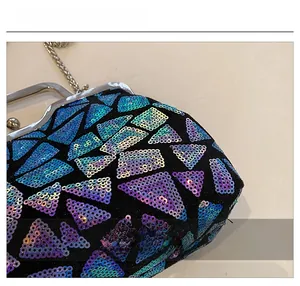 Macro detail of geometric laser sequins and silver metal clasp on black evening shell bag