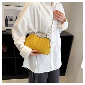 Detail of yellow rhinestone evening bag with silver metal handle and chain strap