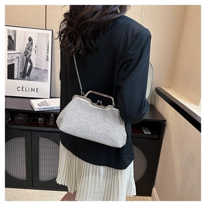 Chic white rhinestone clutch bag with silver chain worn by a model in a stylish setting
