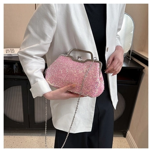 Pink sequin evening clutch with silver frame and chain strap held by a model
