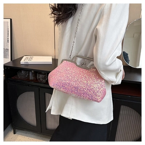 Detail of pink sequin clutch bag with silver chain strap worn by model in elegant setting