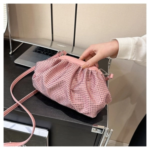 Detail of pink rhinestone pleated cloud clutch showing sparkling gems and soft texture