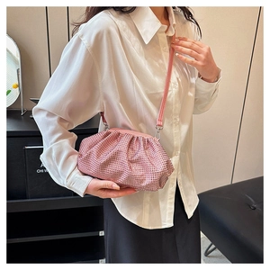 Close-up of pink rhinestone cloud bag with pleated design and thin leather shoulder strap