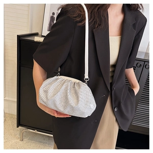 Detail of silver rhinestone cloud bag with a slim leather strap on a model wearing a suit