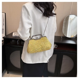 Chic yellow sequin evening bag with gold chain strap shown on a model's shoulder
