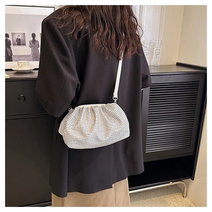 Silver rhinestone cloud bag with pleated design worn over a black blazer by a model