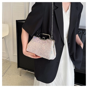 Iridescent sequin evening bag with silver chain worn by model in minimalist setting
