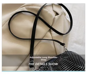Detail of adjustable black leather shoulder strap on a pleated rhinestone clutch bag
