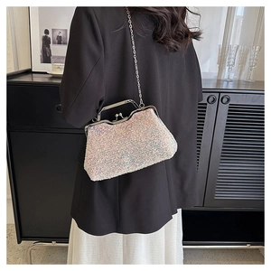 Close-up of white sequined evening clutch with silver frame and delicate chain strap