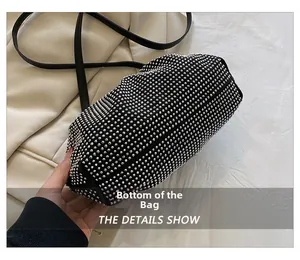 Macro shot showing the flat bottom and rhinestone studded texture of the black clutch bag