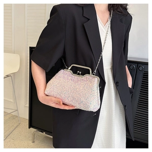Detail of shimmering pink sequin evening bag with silver chain strap on model