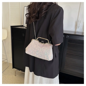 Chic sequined evening clutch bag worn over shoulder with elegant silver chain strap