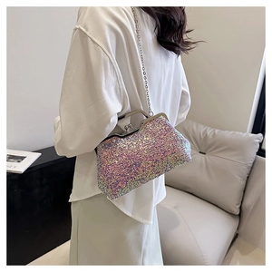Elegant sequin clutch bag with metallic chain strap shown in a modern home setting