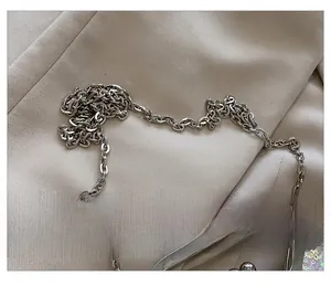 Detailed macro view of silver metal chain strap on a colorful sequin evening clutch bag