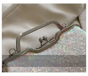 Detailed close-up of high-quality silver metal hardware and sequins on an evening clutch bag