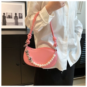 Pink crescent shoulder bag featuring a pearl chain strap and silver heart pendant detail
