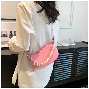 Detail of pink crescent bag with elegant pearl chain and silver heart charms