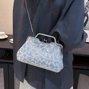 Silver sequin shell evening bag with metal chain strap shown against a grey blazer