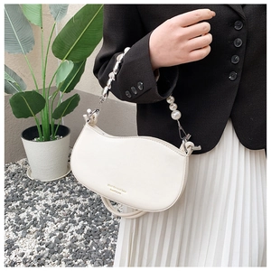 White leather handbag with pearl and silver bead handle shown on person for size scale