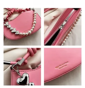 Detail of pink PU leather handbag with pearl chain handle and gold letter printing