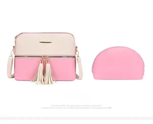 Détail de l'ensemble sac bandoulière rose et beige avec pompons doubles et pochette zippée