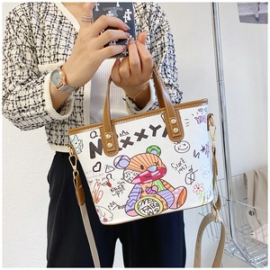 Detail der weißen Graffiti-Tasche mit bunten Bärenmotiven und breitem Textilschultergurt
