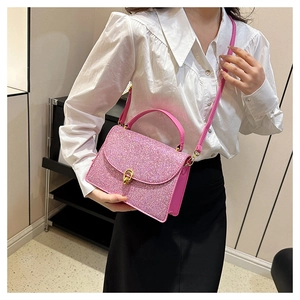 Detail of pink sequin crossbody bag showing the glitter texture and golden metal twist lock