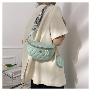 Detail der mintgrünen Stepp-Brusttasche mit geometrischem Gurt und Mini-Anhänger-Etui